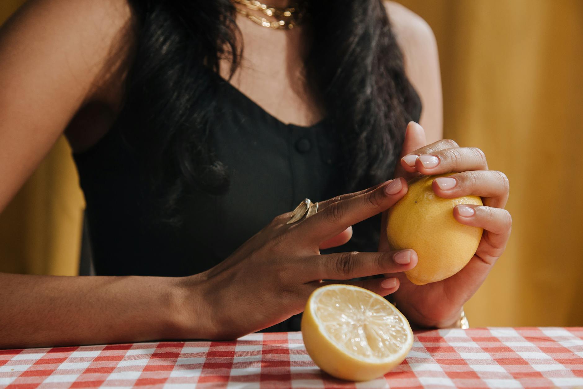 Close-up of hands holding a sleek blue vibrator against a purple background