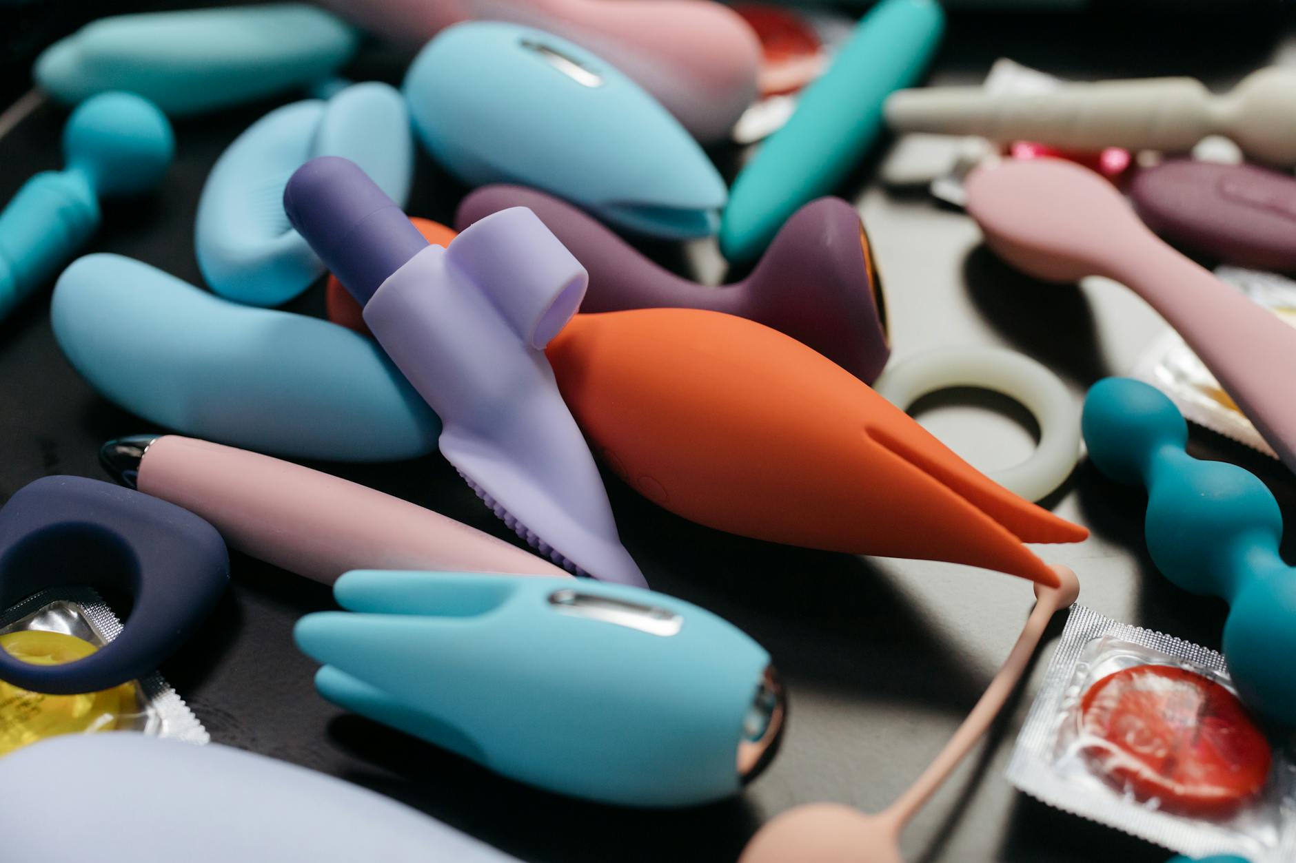A blue silicone clitoral vibrator held in hand against a purple background, showing gentle design for sensitive tissue.