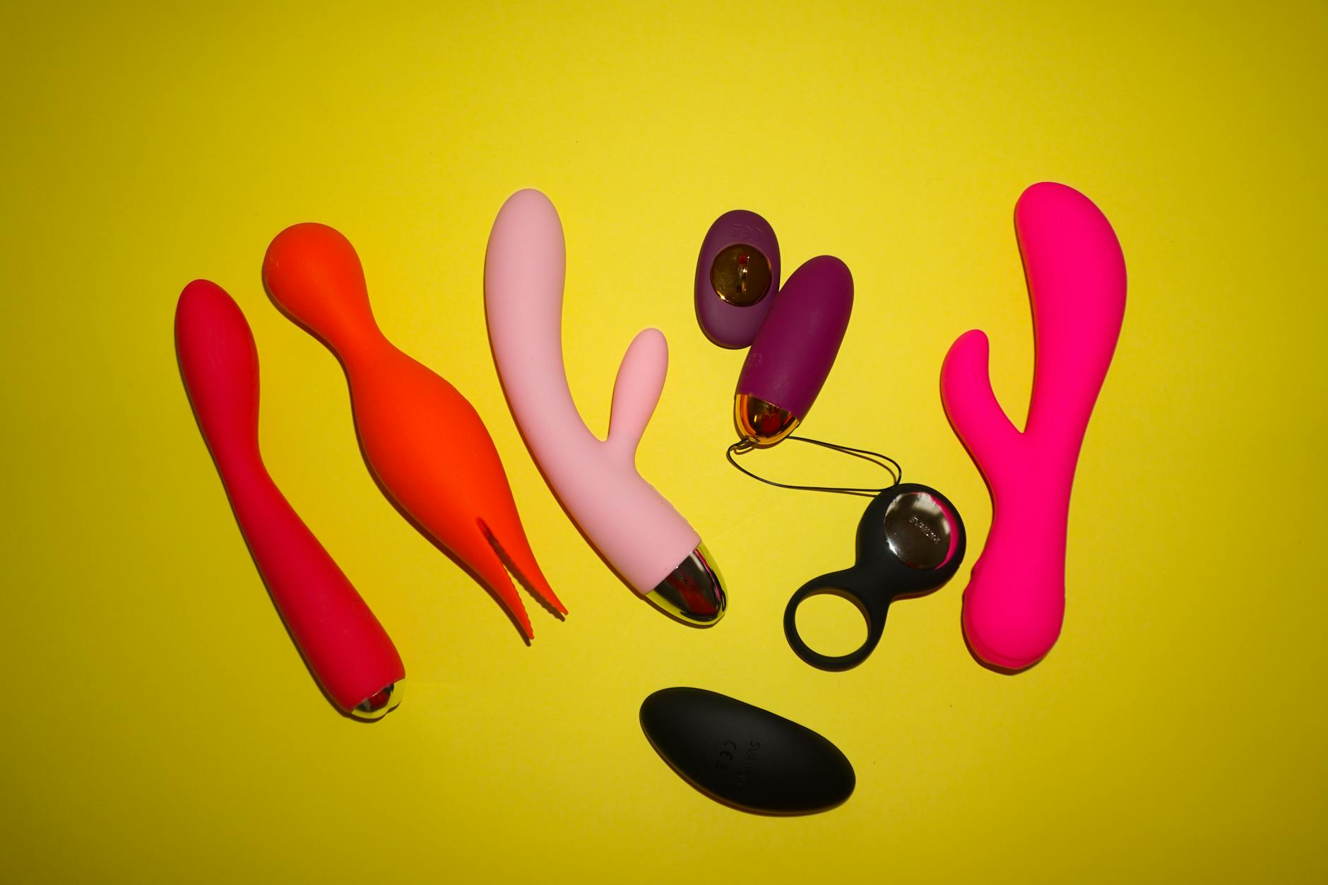 A hand holding a silicone clitoral vibrator, representing gentle, body-safe intimacy